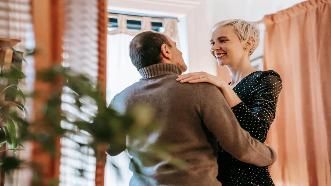 A couple talking while dancing at home