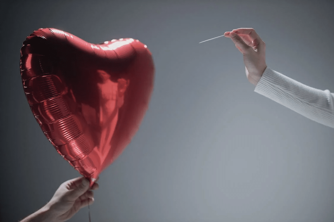Person Holding Red Heart Balloon
