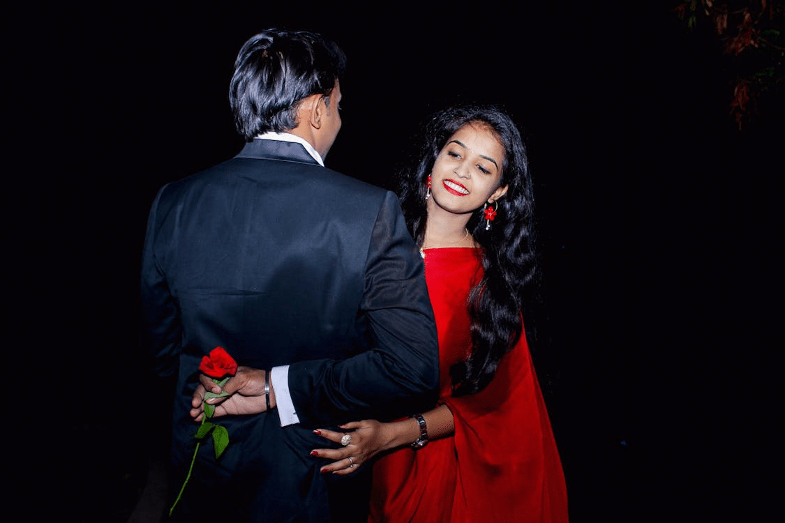 Man with Flower Behind Back Looking at Woman