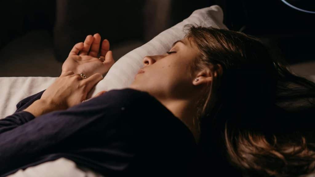 A woman sleeping peacefully on a pillow in a dimly lit room.