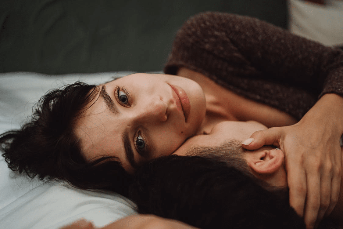 A couple cuddling in bed