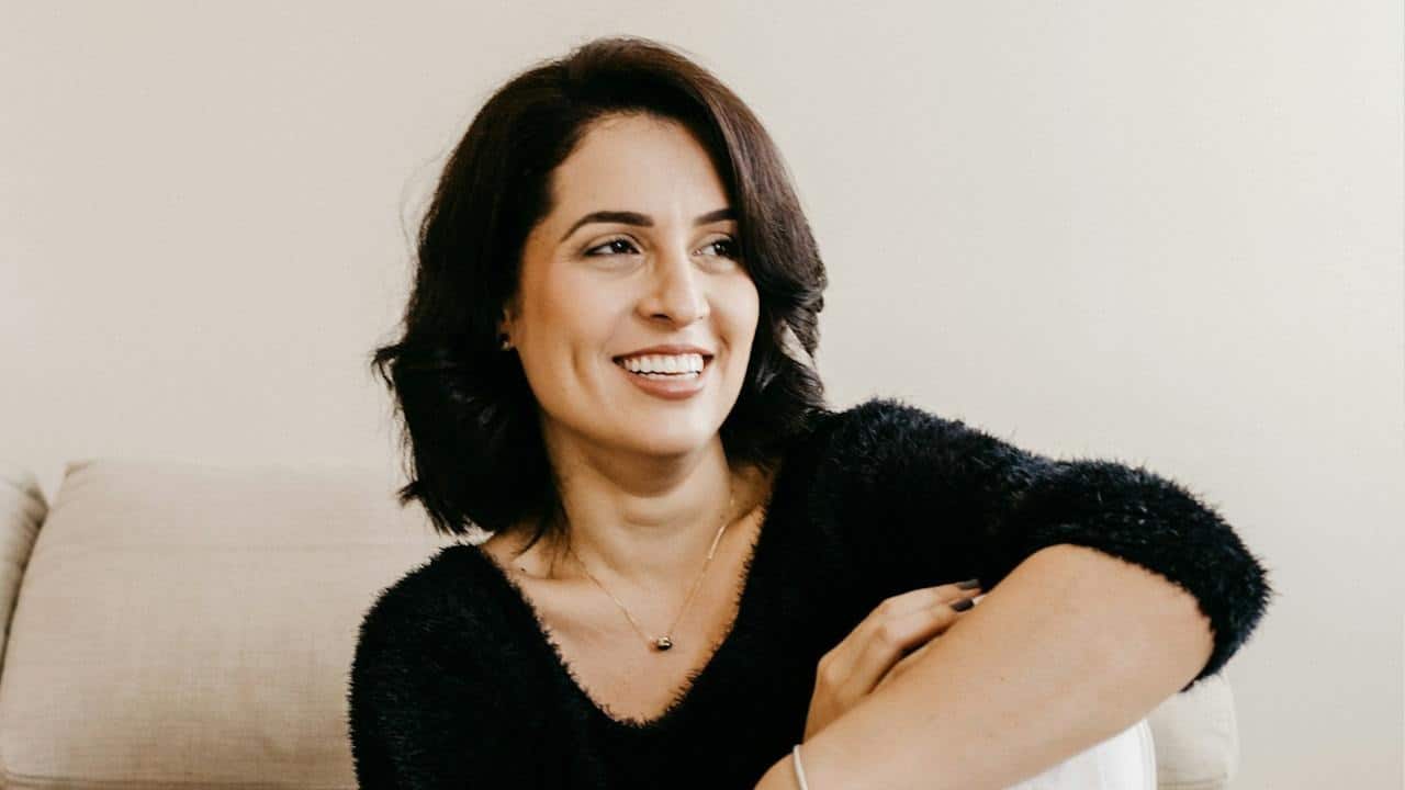 An attractive older woman wearing a black sweater and looking to the side.