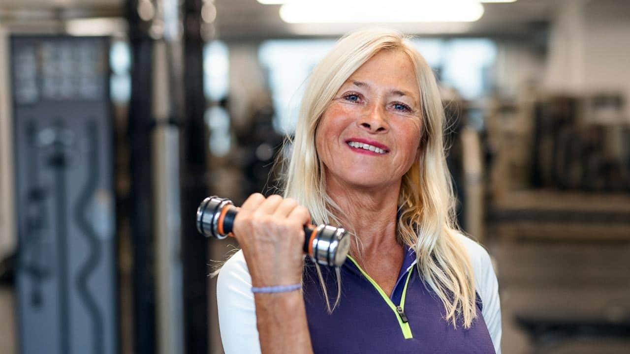 An older woman working out at the gym.