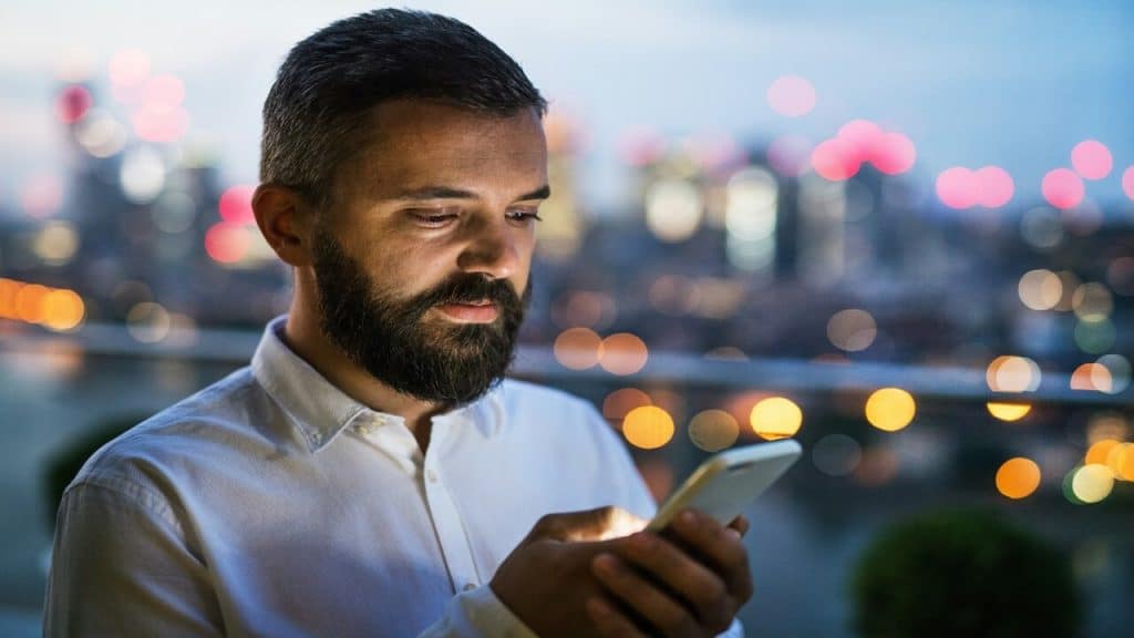 A man looking sad while looking at his phone