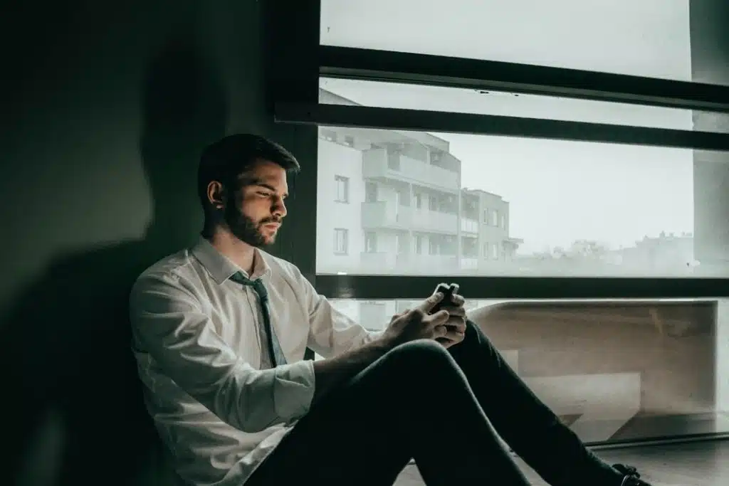 A sad man looking at his phone