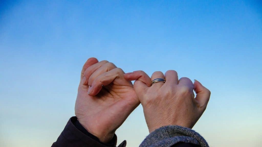 Two people doing a pinky promise