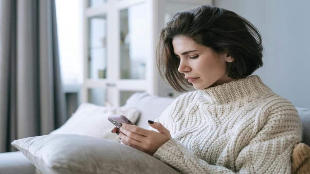 A woman looking sadly at her phone