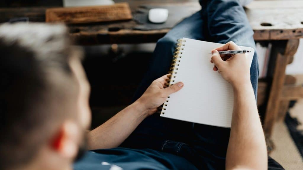 A man writing on his notebook