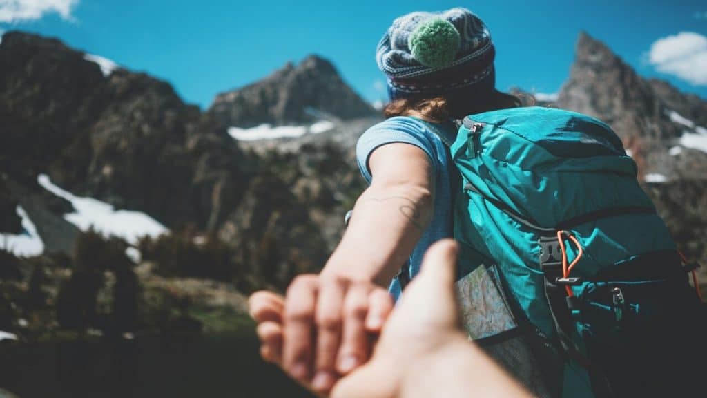 A woman leading her man through a hike