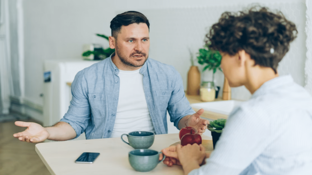 A man berating his wife while they eat