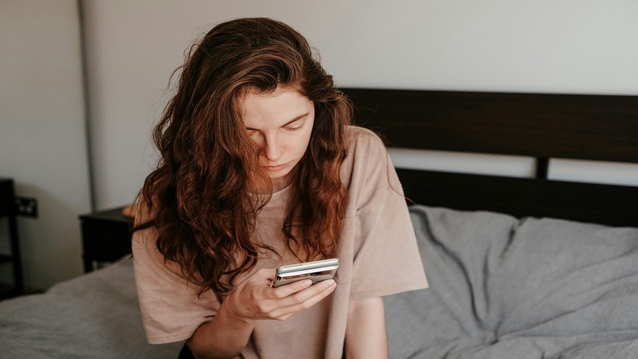 A woman looking sadly at her phone