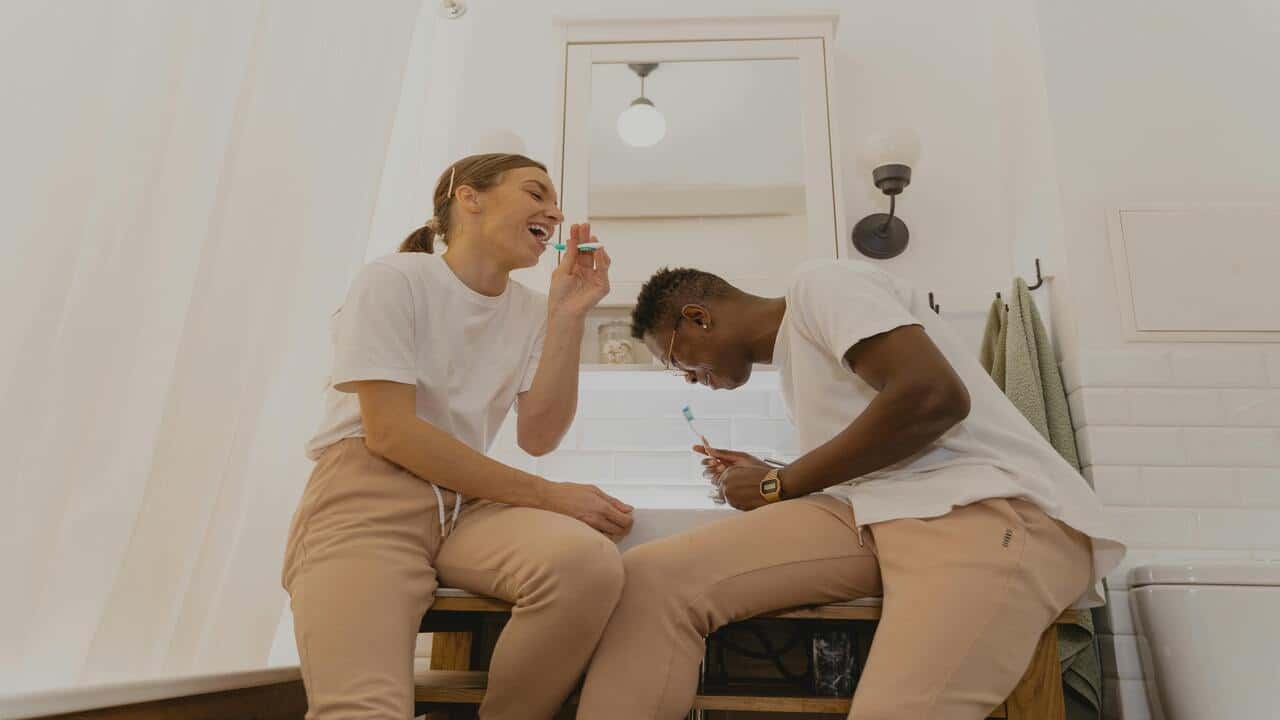 A couple brushing their teeth together