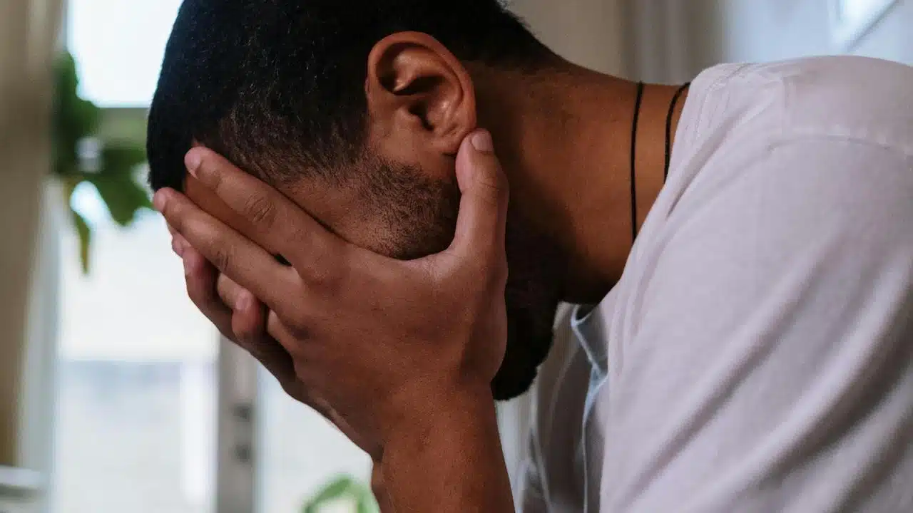 A man sitting with his head in his hands.