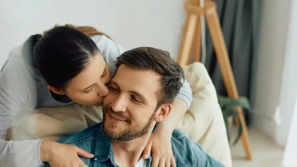 A woman kissing a man on the cheek