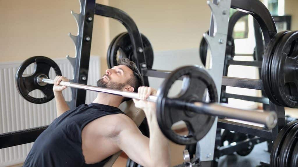 A man lifting a barbell on a bench press machine