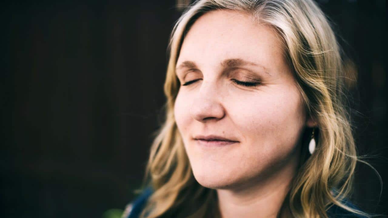 A mature woman with her eyes closed.