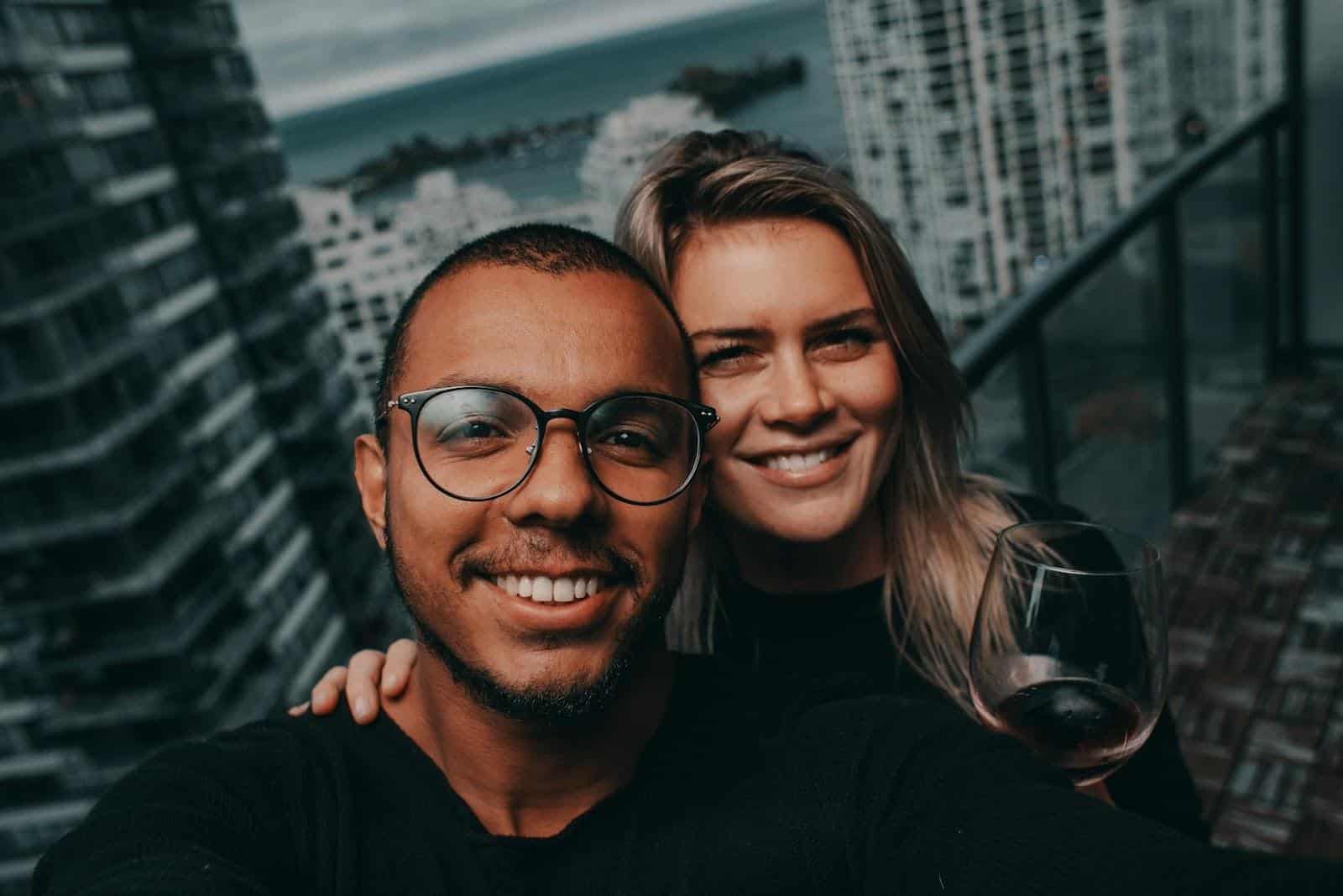 A couple standing near a fence.