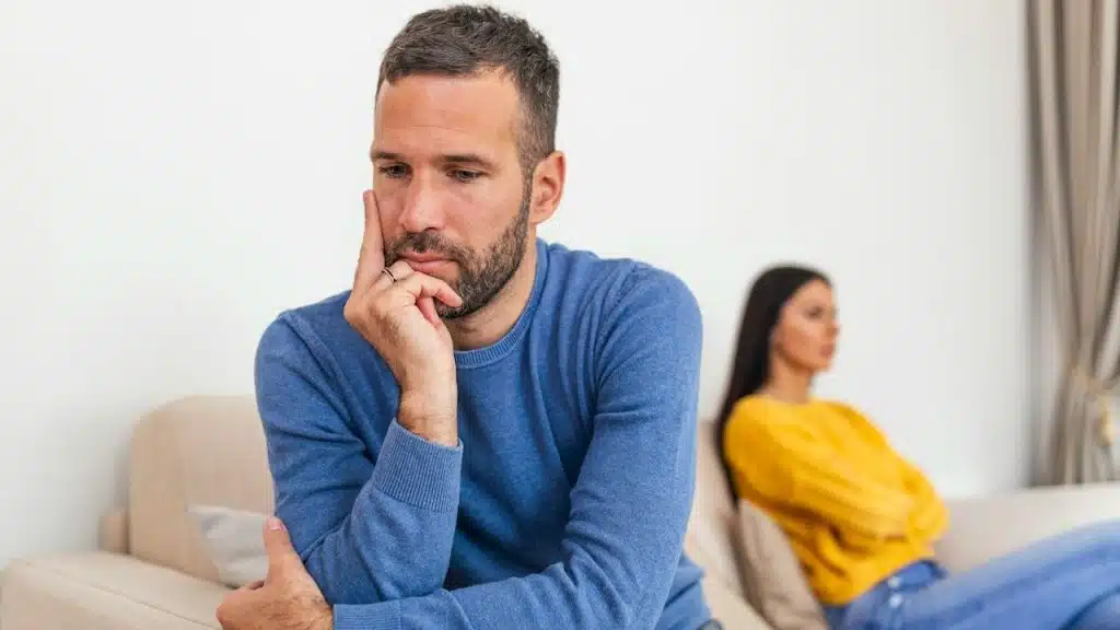 A man and a woman sitting separately after a fight at home.