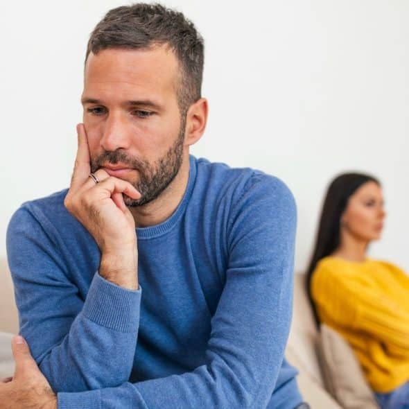 A man and a woman sitting separately after a fight at home.