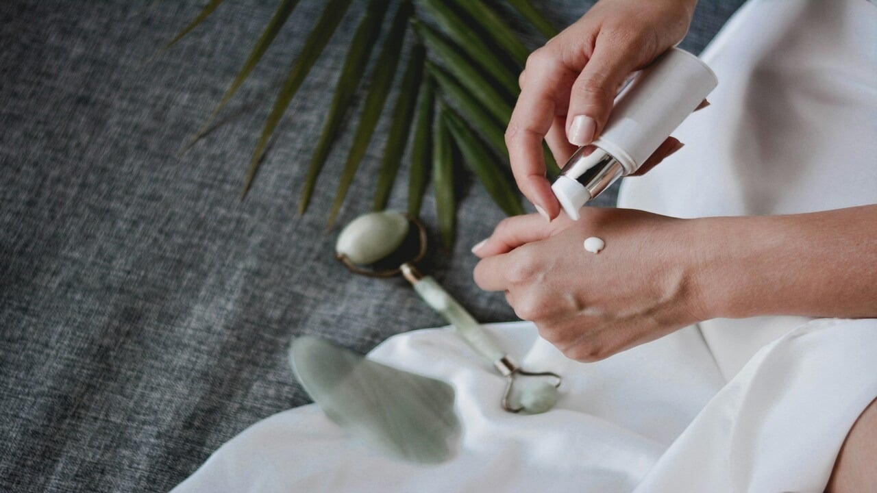 A woman pouring skincare on her hand