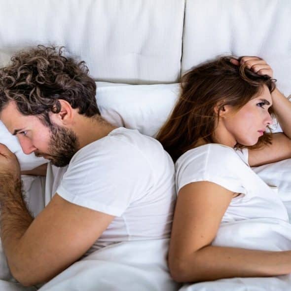 A couple looking upset in bed