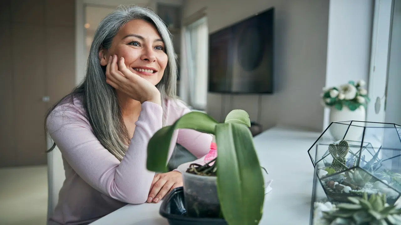 A woman smiling while looking out the window 
