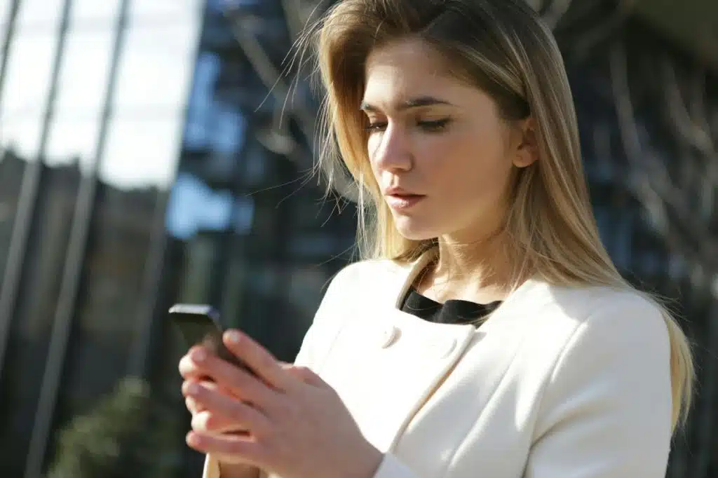 Woman using a phone with an expression on her face