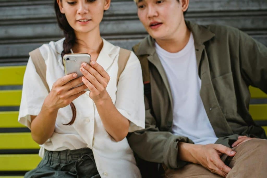 Woman holding a phone while with a man