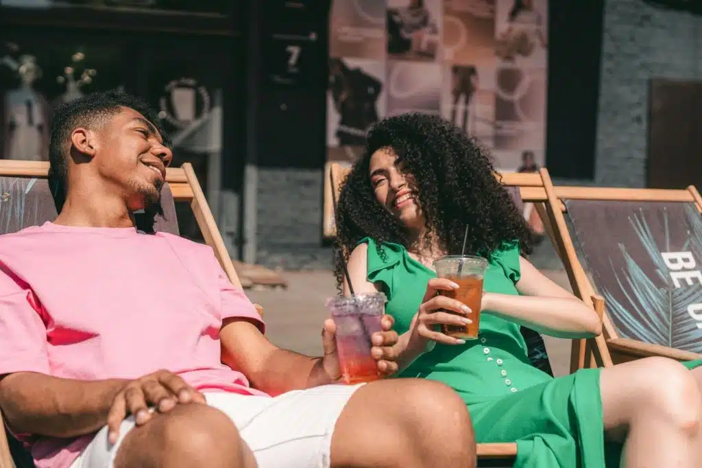 A man and woman sitting and having drinks 
