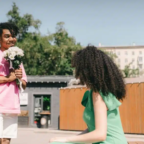A man giving a flower to woman