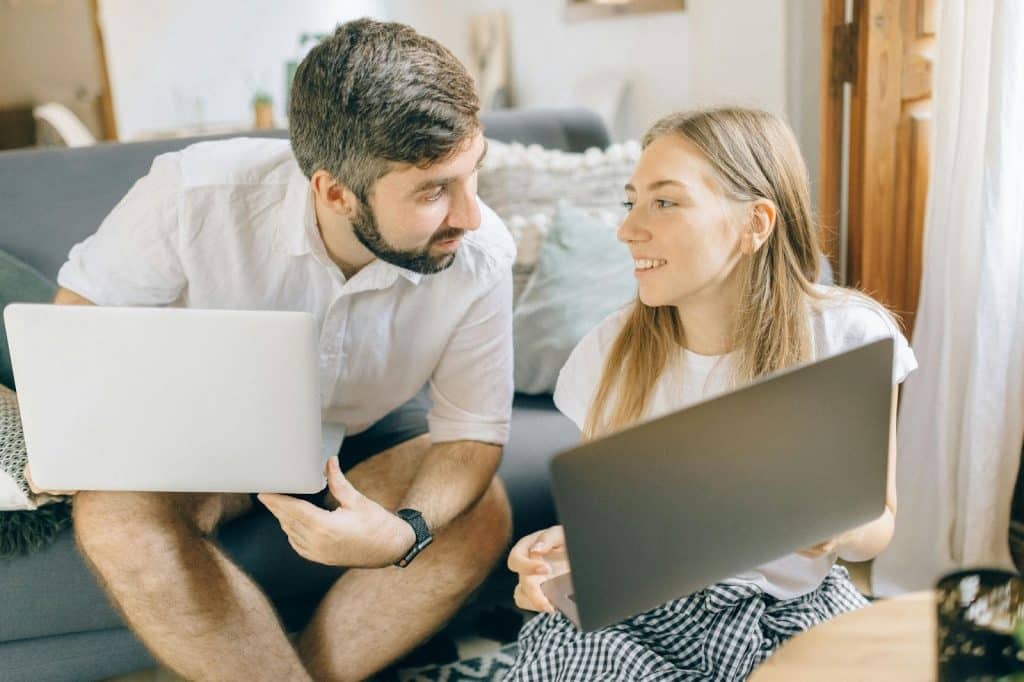 A man and woman holding a laptop