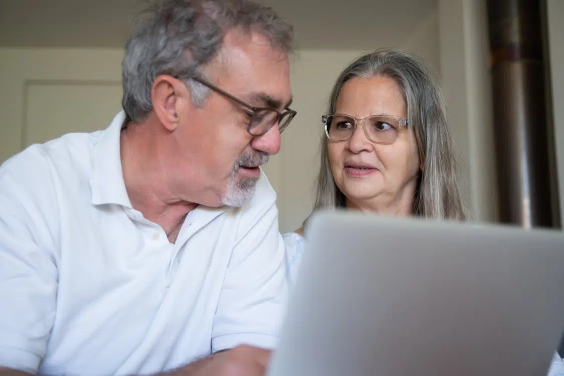 A couple sitting using a laptop