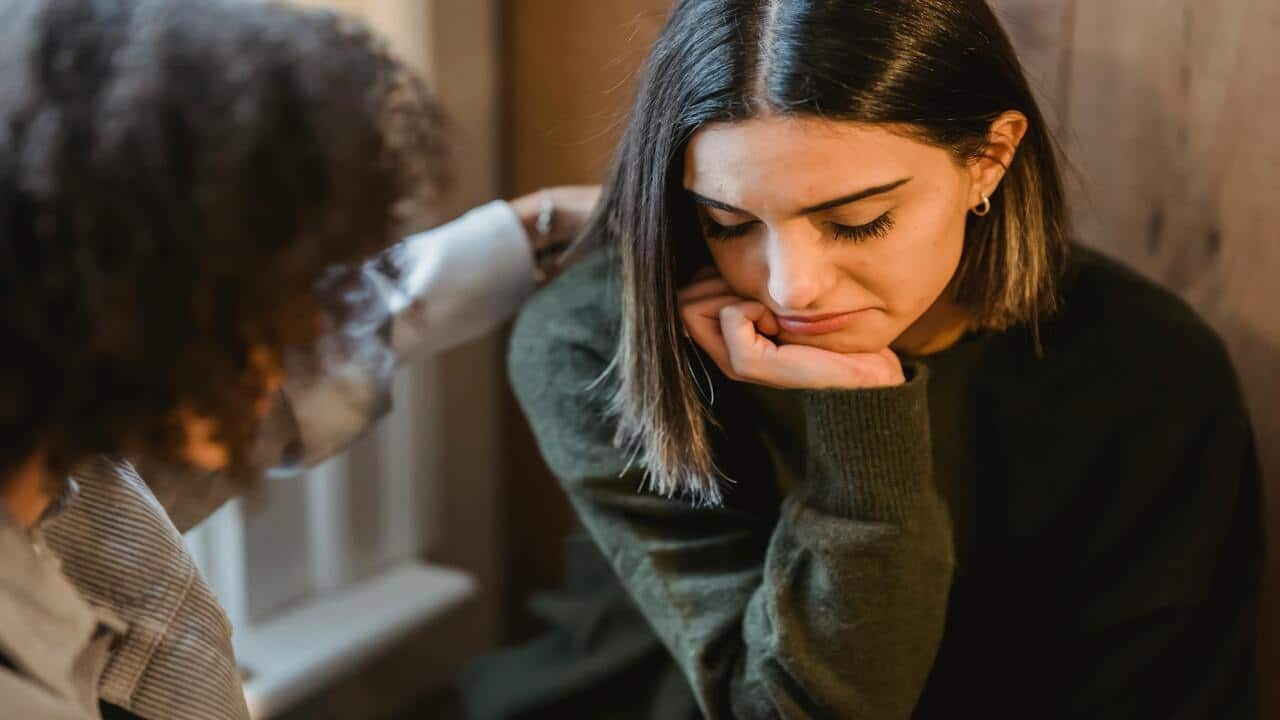 A woman comforting a sad friend