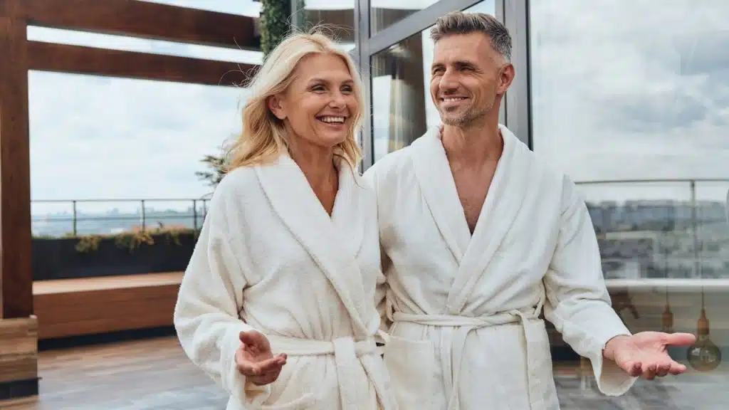 Beautiful,mature couple in bathrobes relaxing in luxury hotel outdoors.