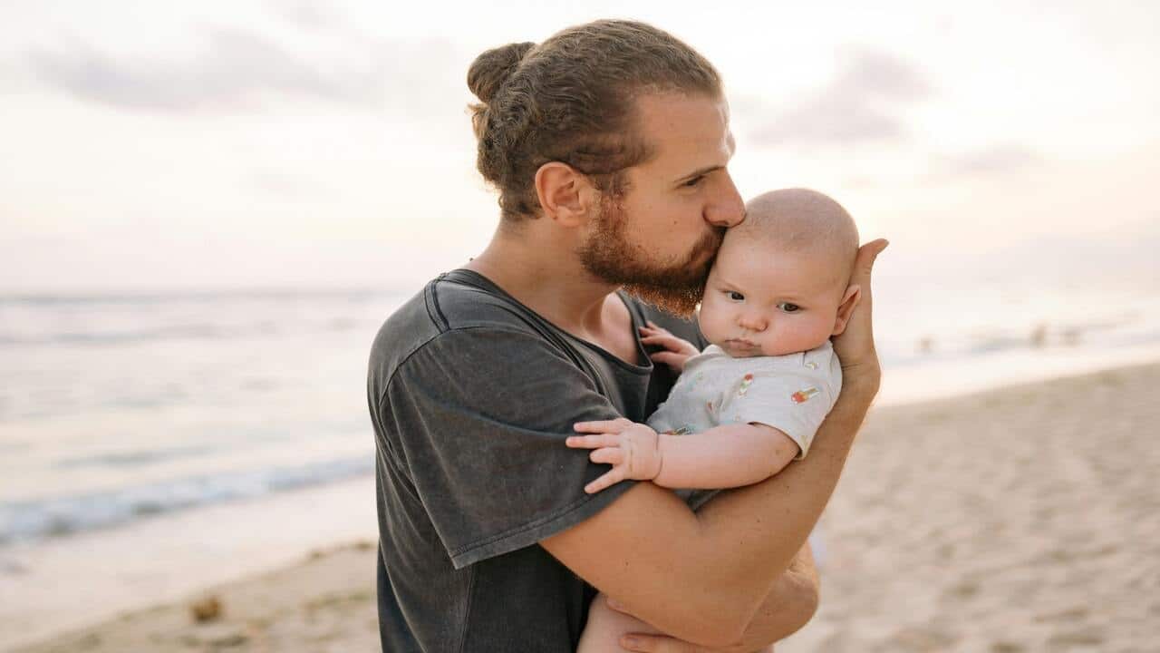 A dad with his baby on the beach