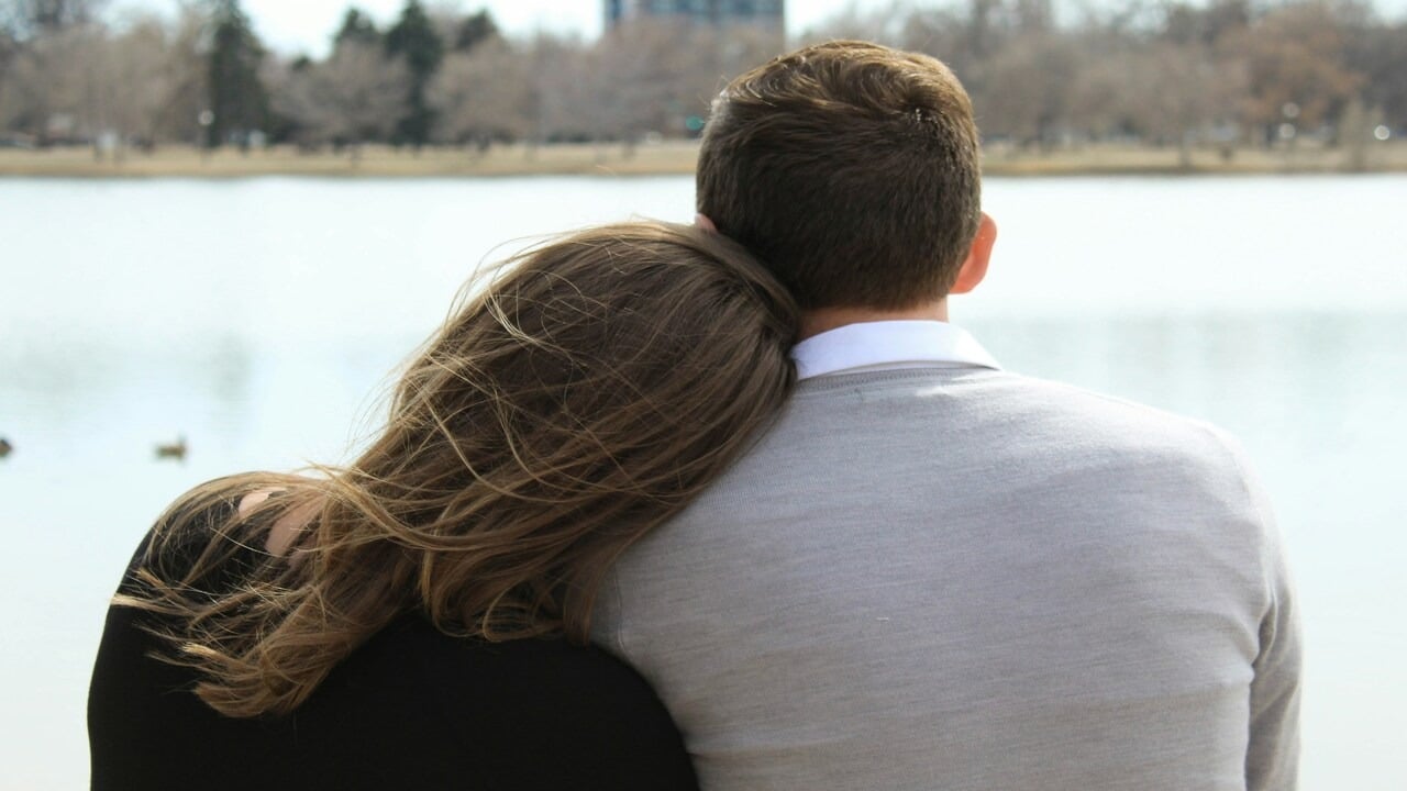 A woman leaning on her husband
