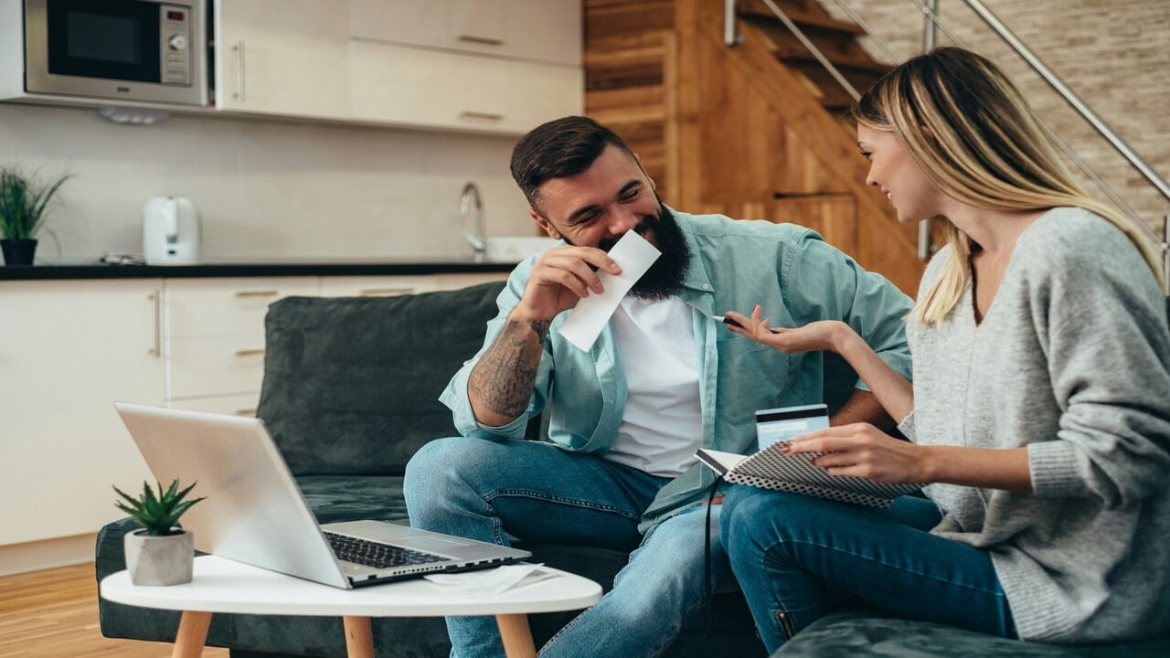 A couple laughing while online shopping