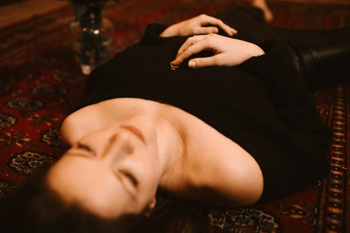 Sad Woman Lying on the Floor with a Ring on her Chest