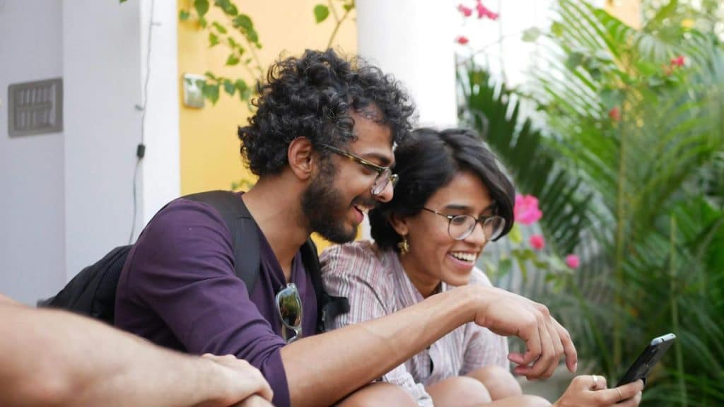 A man in a T-shirt sitting beside a woman in a purple shirt.