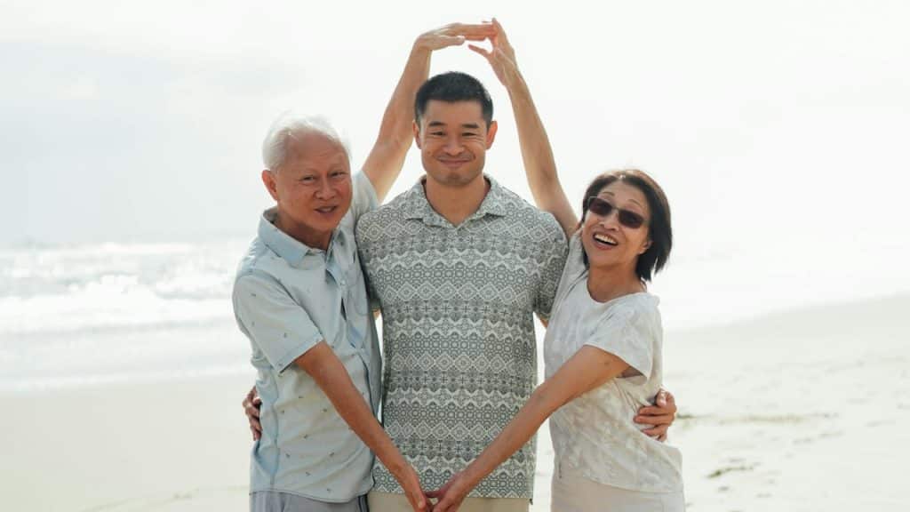Family forms heart on beach.