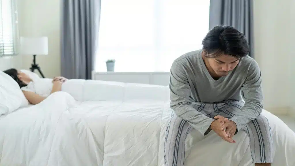 A couple looking sad in the bedroom