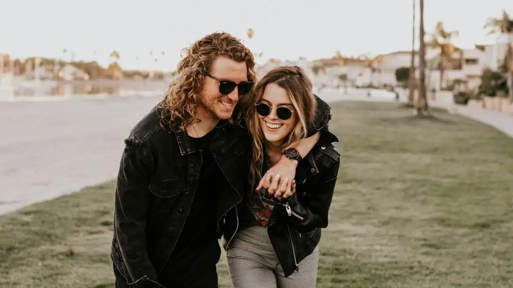 A couple holding each other walking in nature.