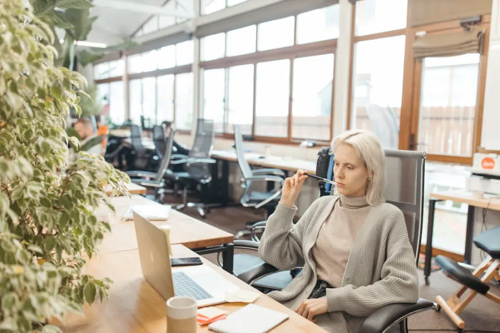 A Woman Sitting on the Office Chair at the Work Desk