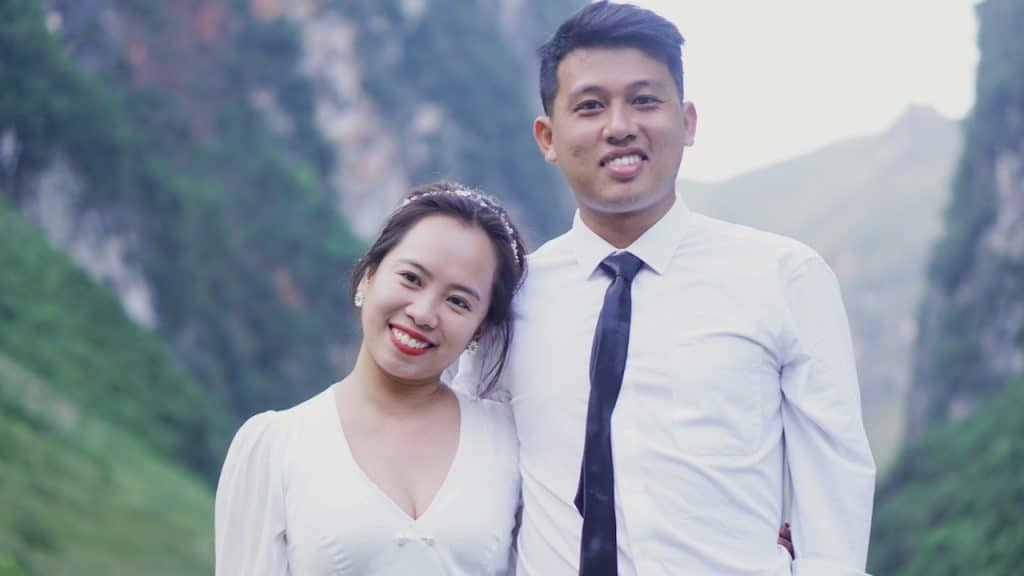 A man in a white dress shirt beside a woman in a white long-sleeve shirt.
