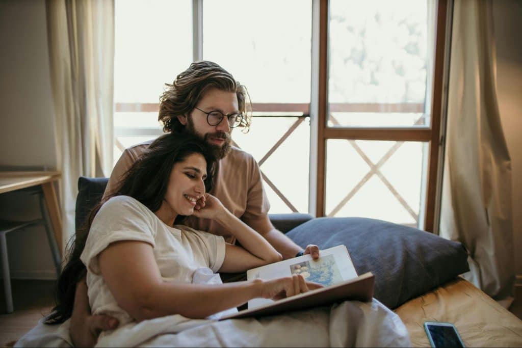 A man and woman at the bed