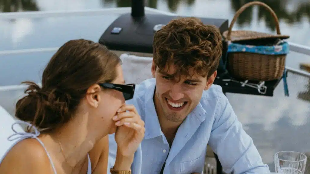 A couple sitting outside and laughing together.