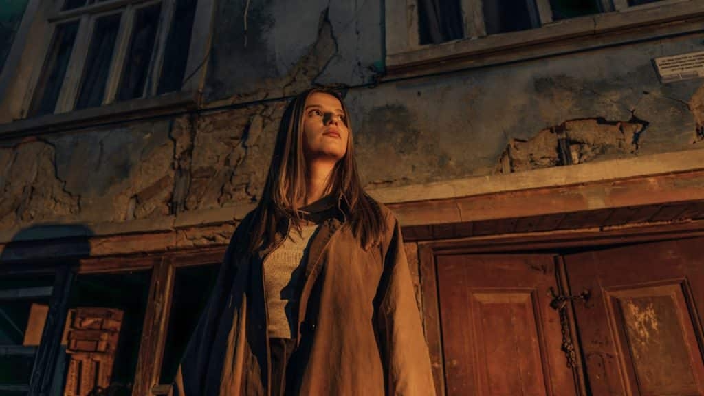 A woman standing outside an old building.