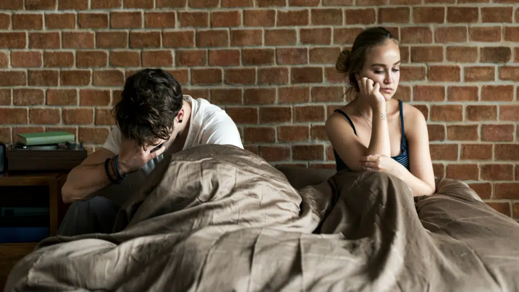 A couple looking sad in the bedroom