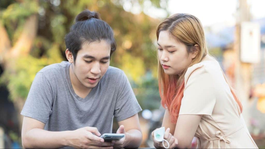 A woman checking man’s phone