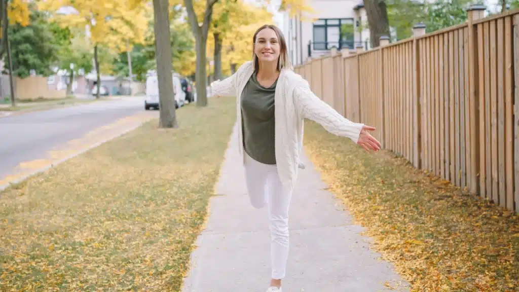 A beautiful woman with short hair is walking on the street in fall.